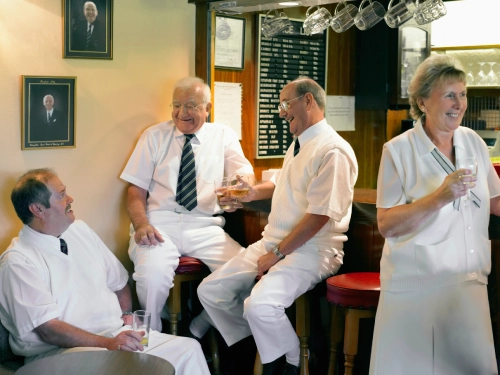 Senior Men And Women Dressed In Lawn Bowling Sportswear Enjoying A Drink In A Clubhouse Bar
